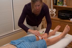 A woman is giving a man some medical care.