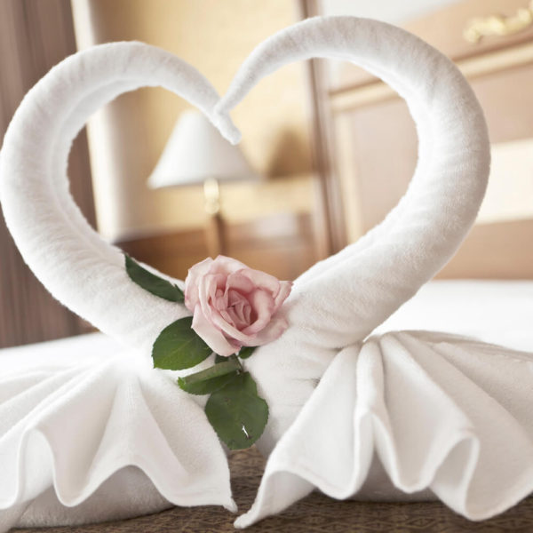 A towel shaped like an animal with a rose on it.