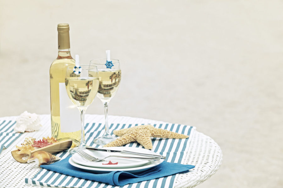 A table with two wine glasses and plates on it.