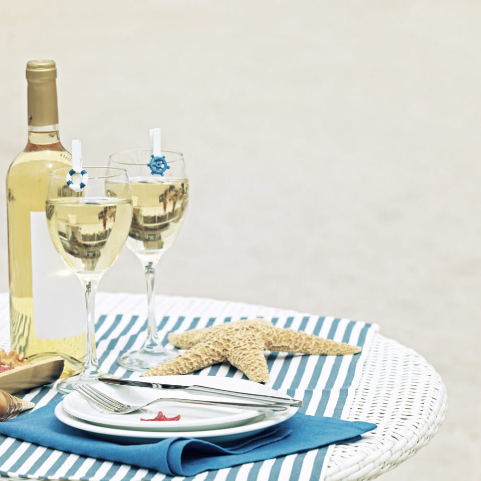 A table with two wine glasses and plates on it.