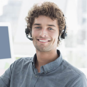 A man with headphones on smiling for the camera.