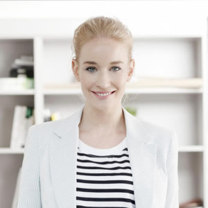 A woman in white jacket and striped shirt.