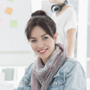 A woman with a scarf on smiling for the camera.